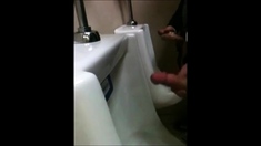 two slim dicks getting wanked at the urinals